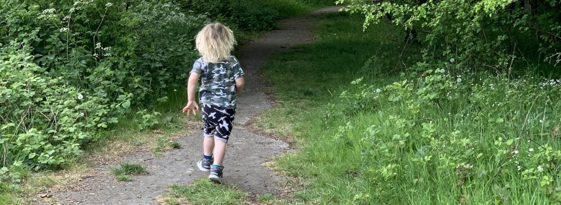 Get outside more-A young boy leaving his home to explore the outdoors along a forest trail.