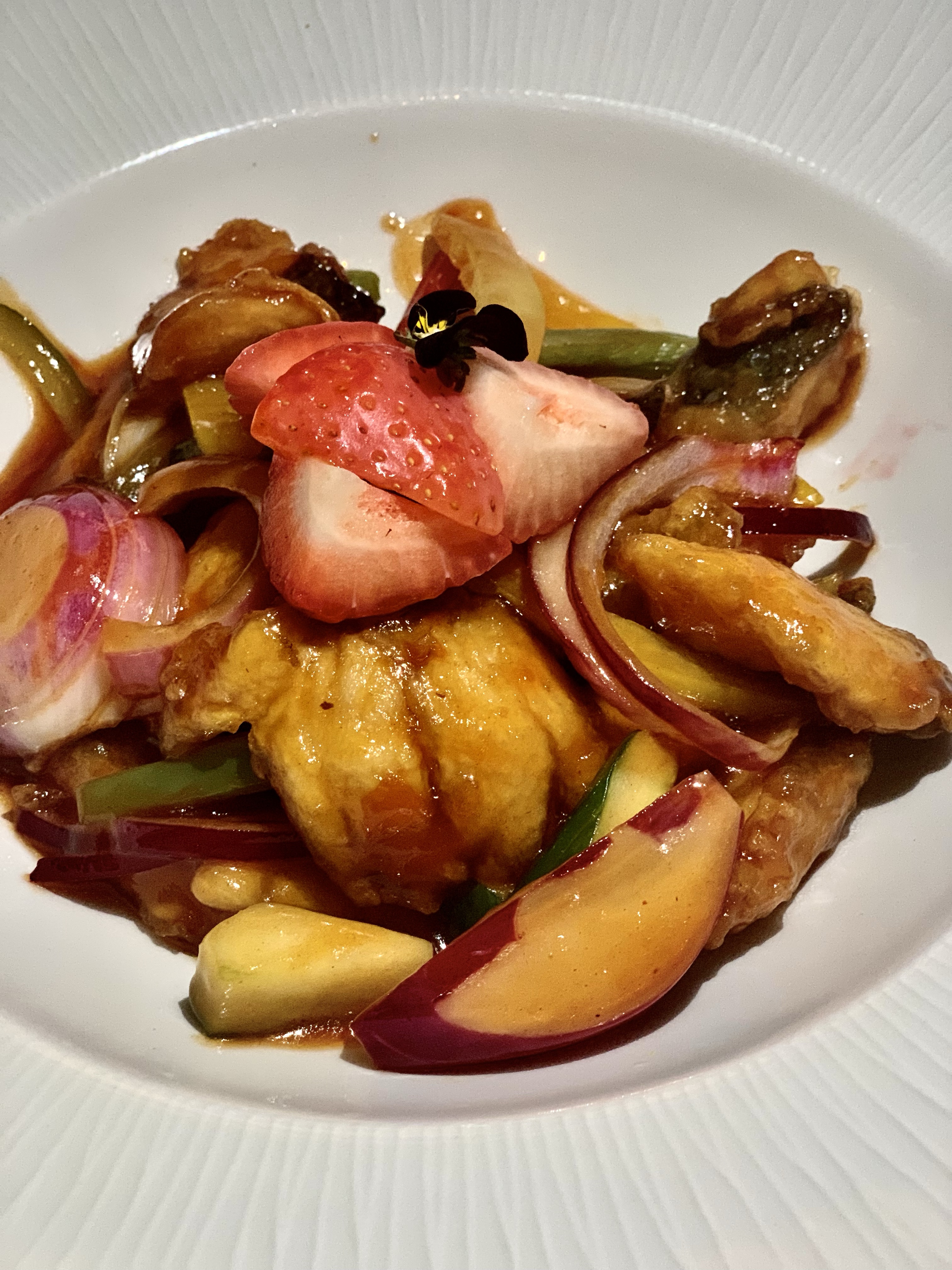 Lulu Wild Birmingham review - strawberry sweet and sour bass. A large slices strawberry sits at the centre of this plate featuring the sea bass and accompanying stir fried vegetables in a sticky sweet and sour sauce 