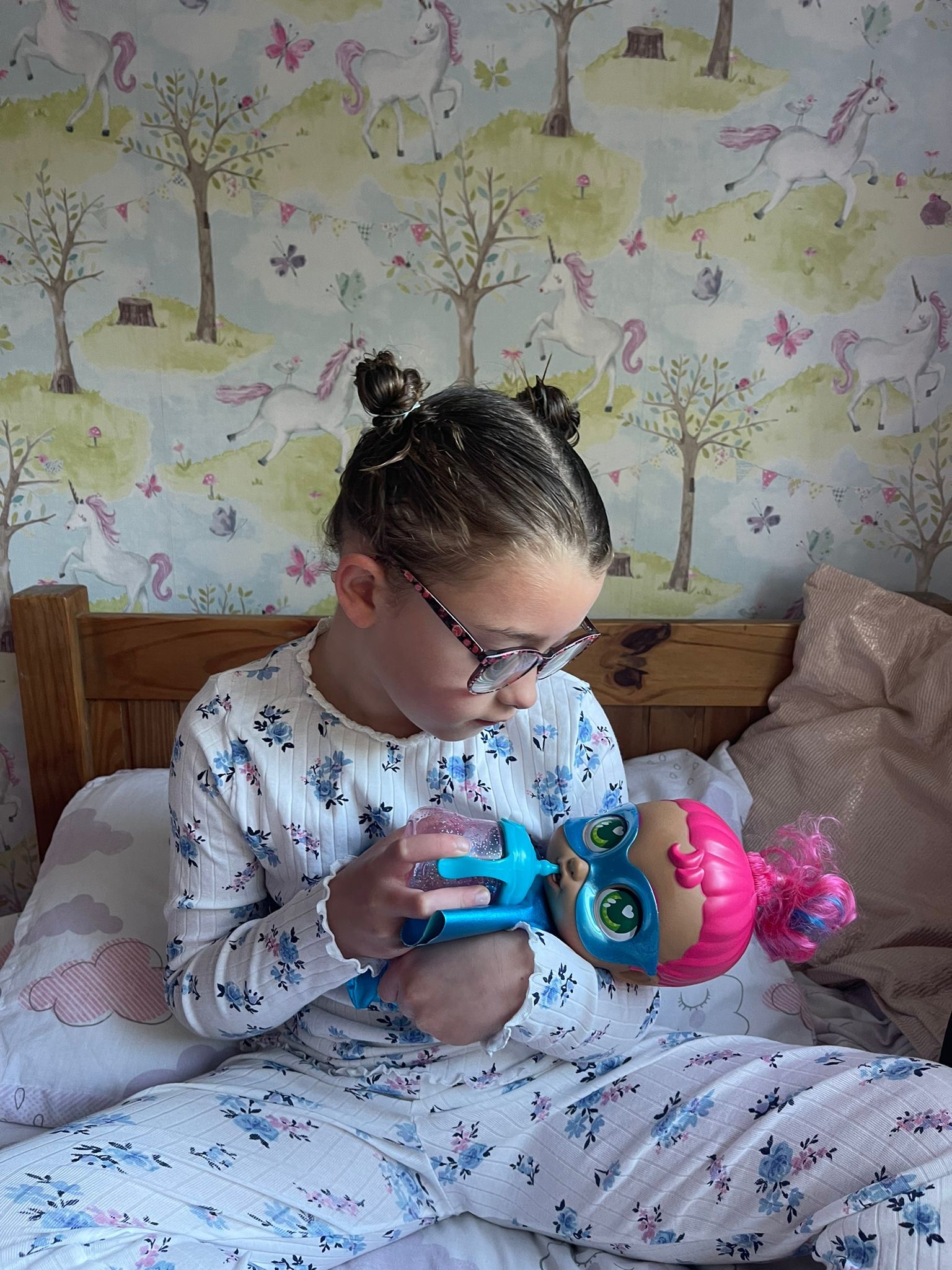 A girl in pajamas holding a toy.