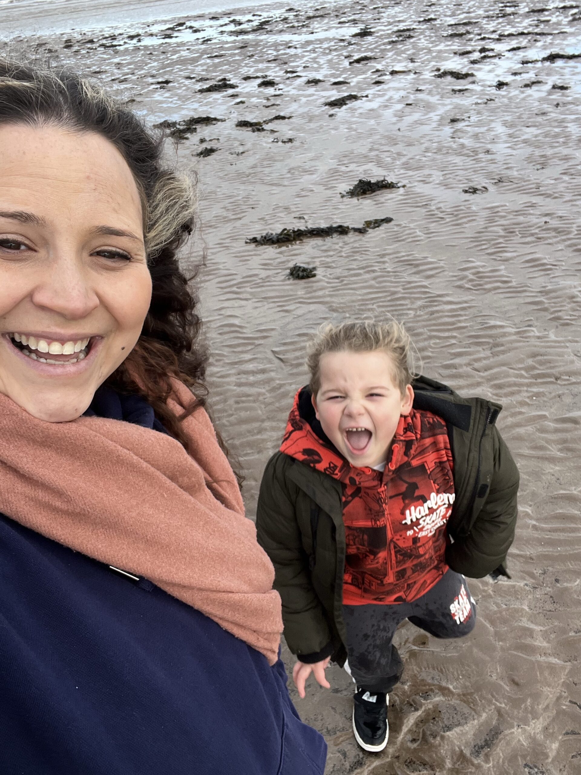 a woman and a child playing on the beach.