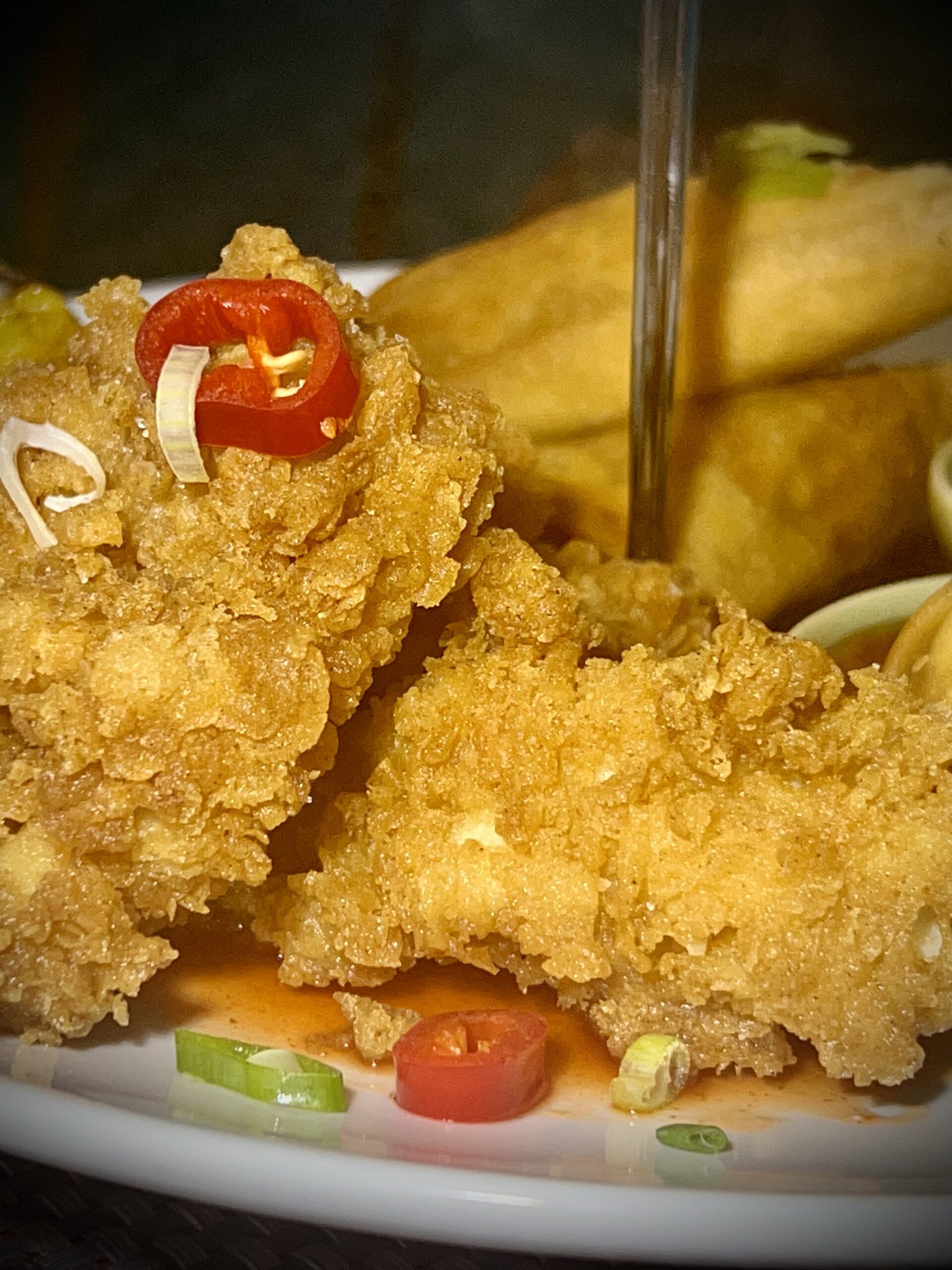 a white plate topped with fried food and french fries.
