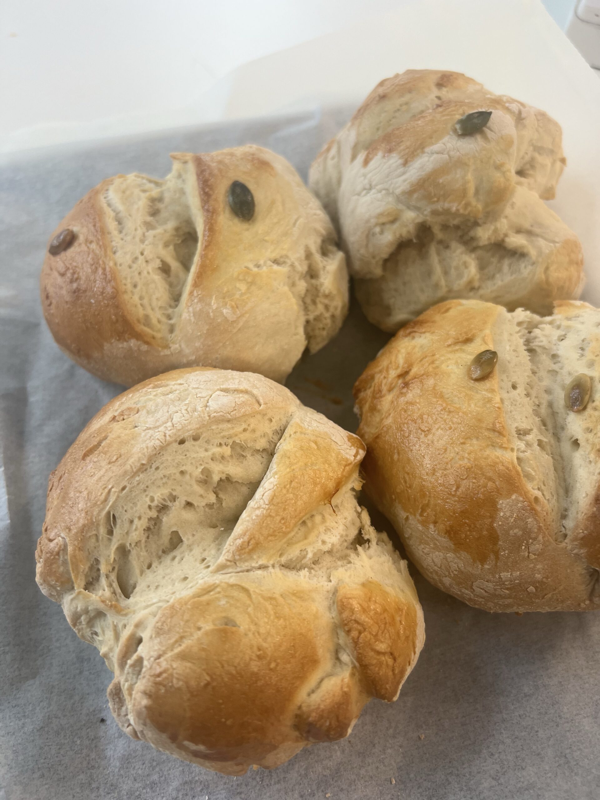 four buns are sitting on top of a piece of paper.