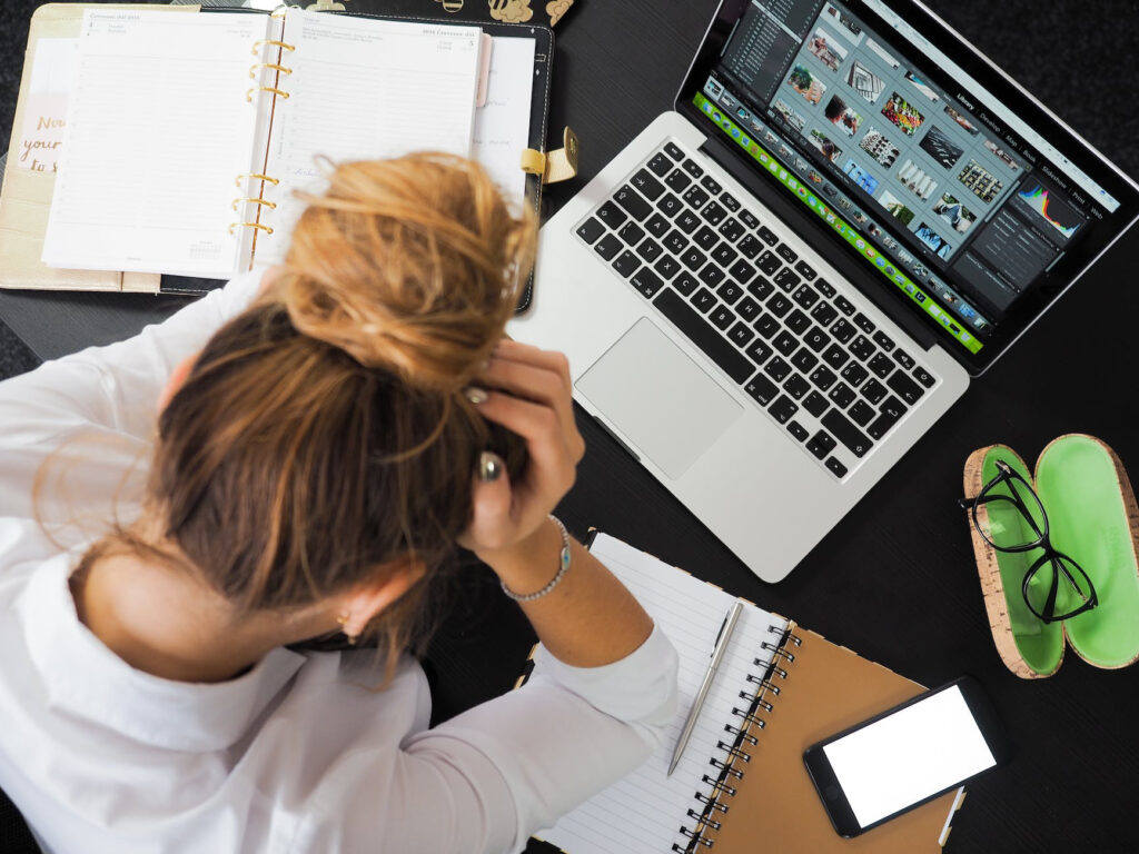 A woman is sitting at a desk with a laptop.