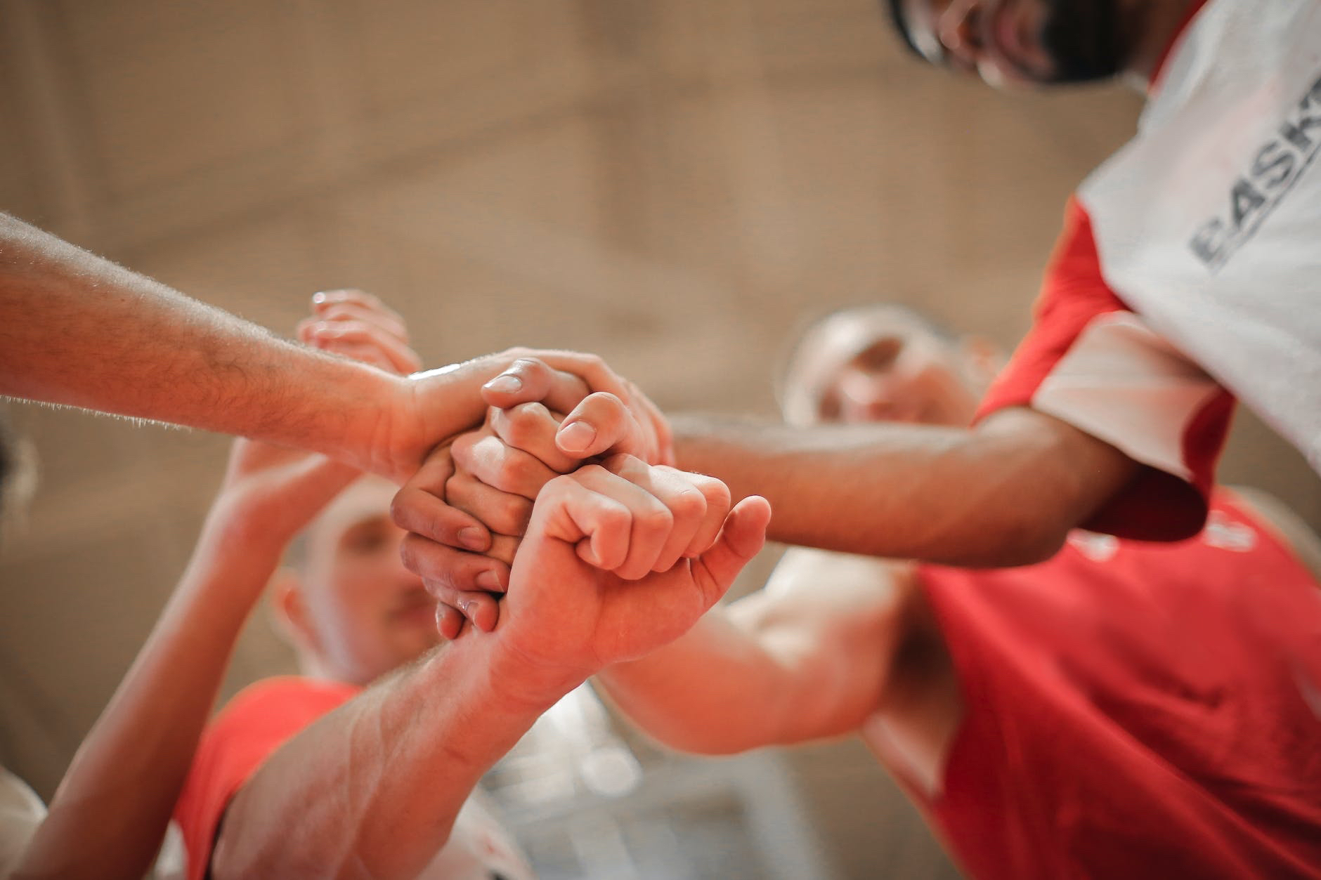 A group of basketball players putting their hands together.