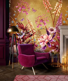 A magenta armchair with a golden floor lamp beside it stands against an ornate floral wallpaper, near a lit fireplace with candles on the floor. A decorative pink rug partially covers the wooden floor.