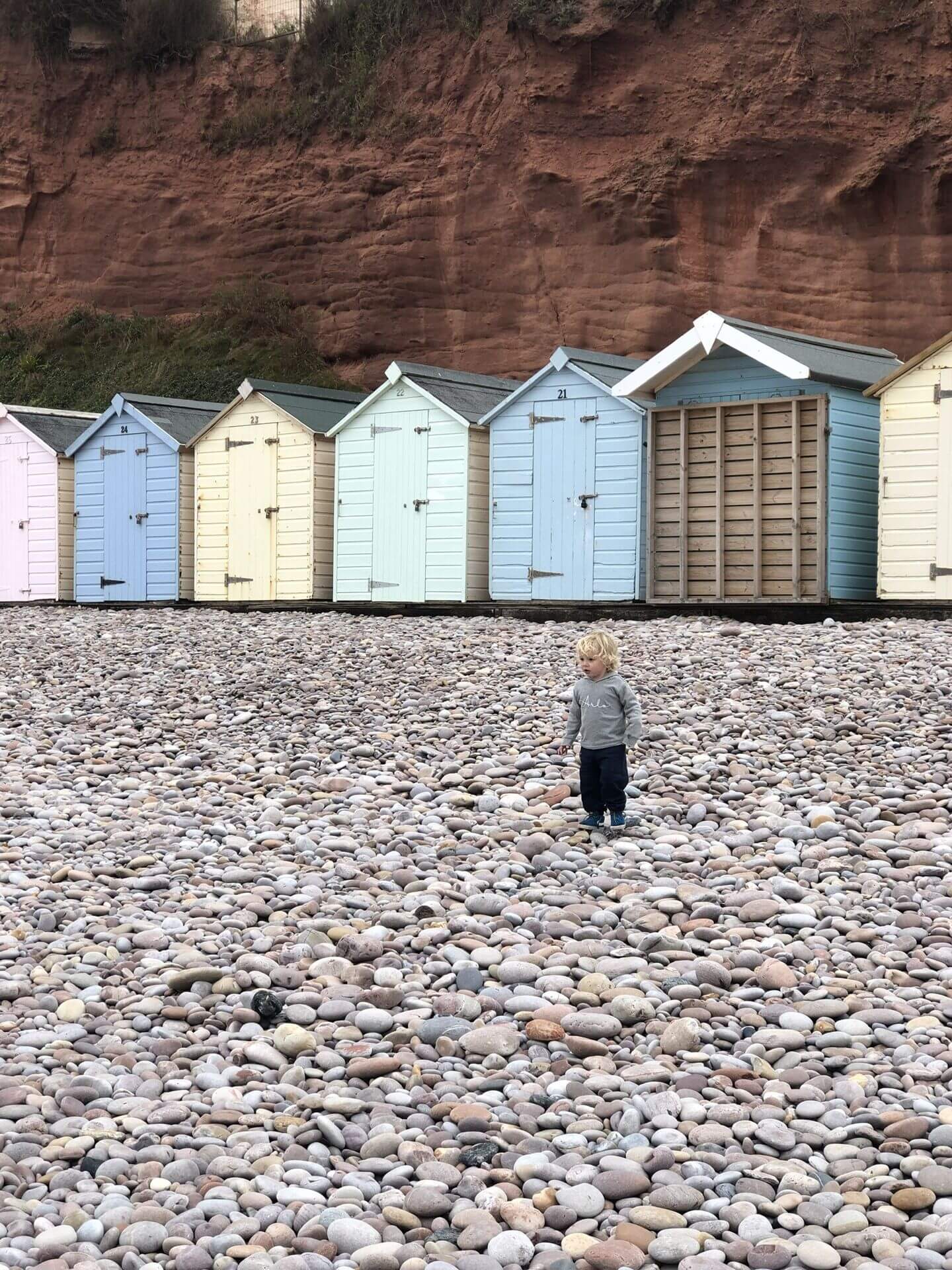 Colourful beach huts beneath the red cliffs near Devon Cliffs Haven