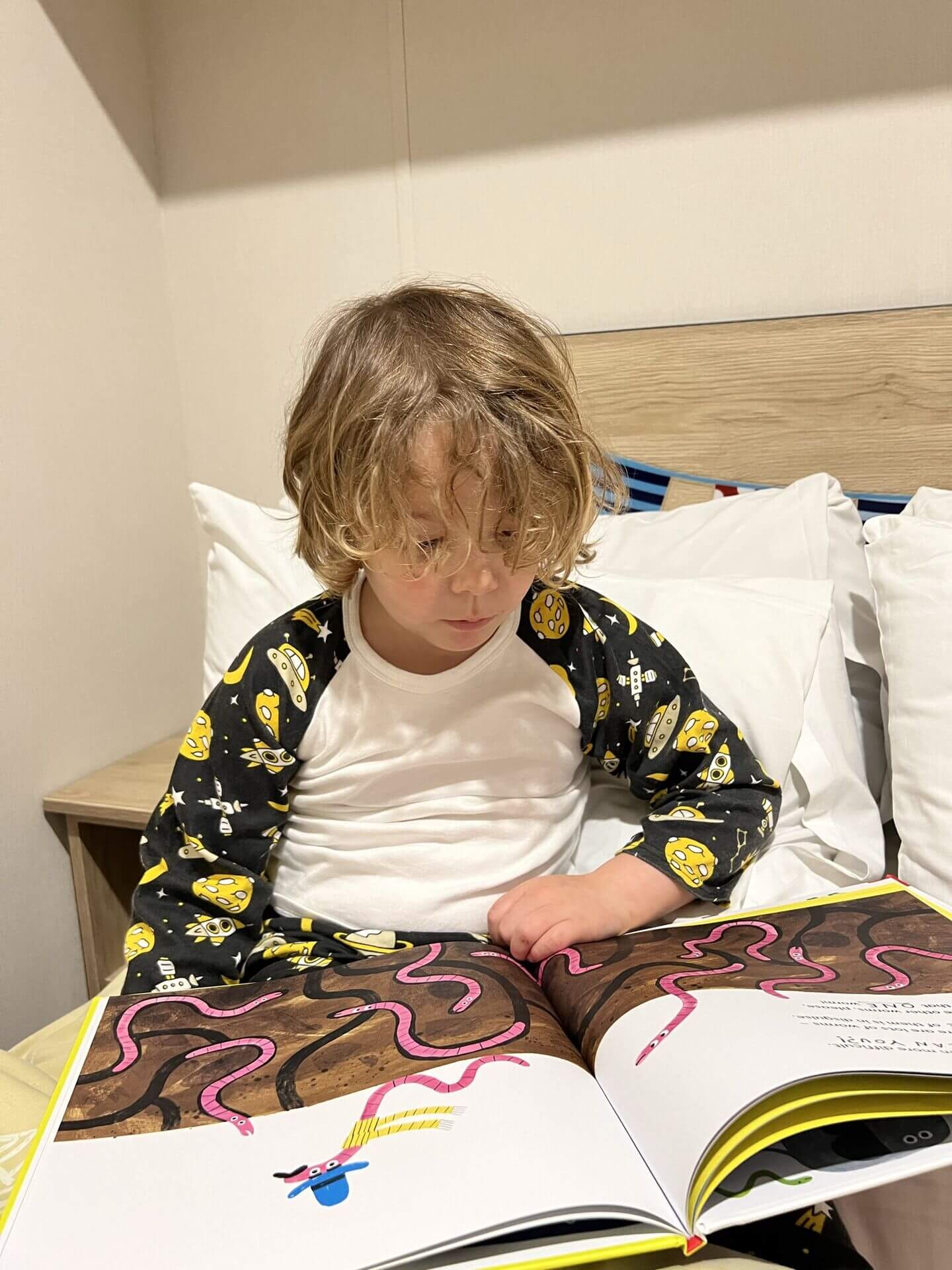 Boy reading a bedtime story in the caravan at Devon Cliffs Haven